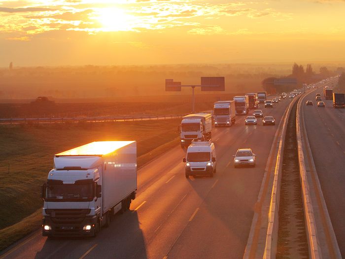 cars and trucks on the interstate at sunset