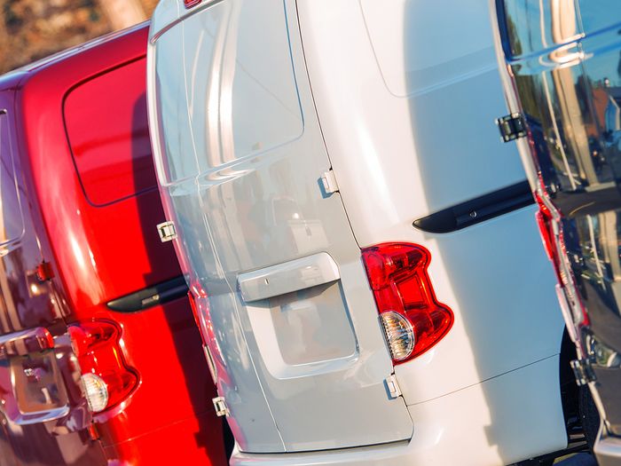 multicolored cargo vans parked in parking lot