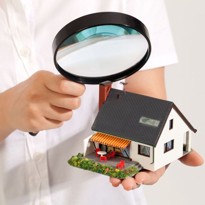 analyzing model home with a magnifying glass