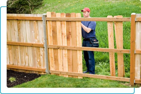 a man installing a fence Fencing.jpg