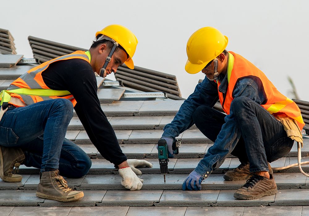 Image of two roofers working on  a commercial roof