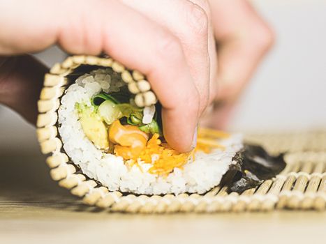 Image of a person rolling sushi