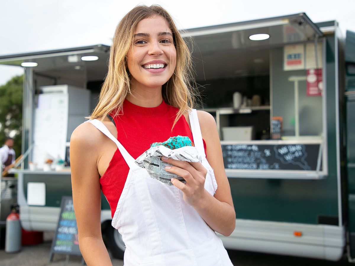 happy woman eating from food truck