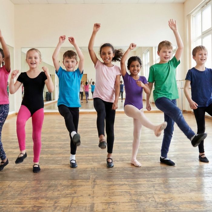 group of children actively dancing together in a studio line
