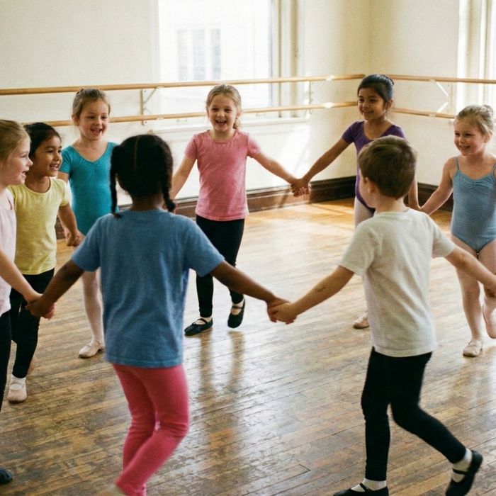 group of young children in a dance class hold hands
