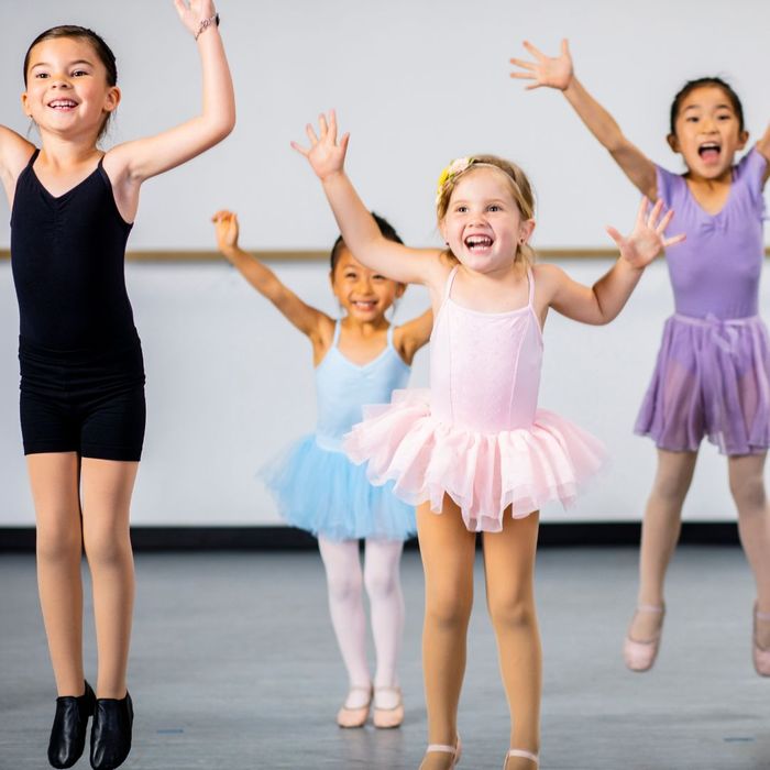 happy children in dance clothes jumping together