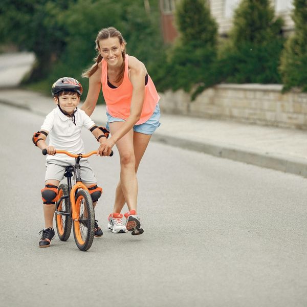 Mother helping her son ride a bike