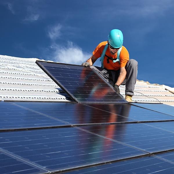 contractor installing solar panels on a roof