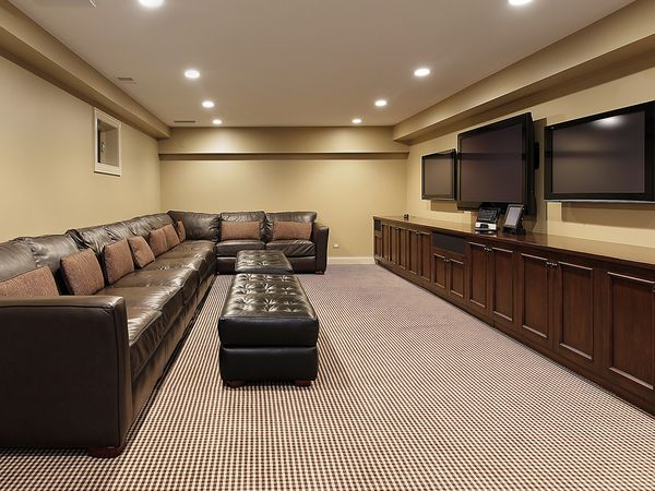 Screen room with three televisions and a large couch
