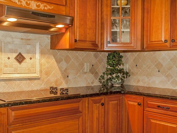 Traditional kitchen with stone backsplash and granite countertop