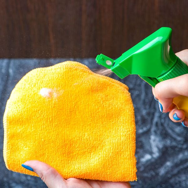 spraying towel to clean countertop