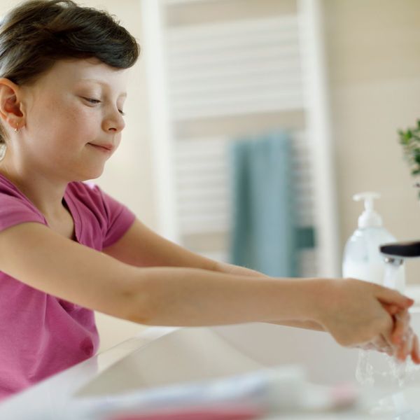 kid washing hands at sink
