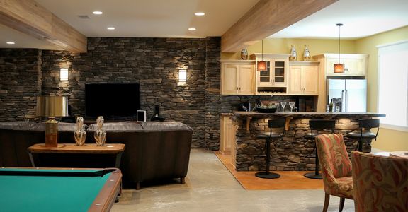 Man cave with television, pool table, and a bar