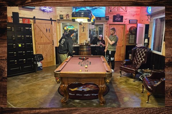 People playing pool in a cigar lounge.