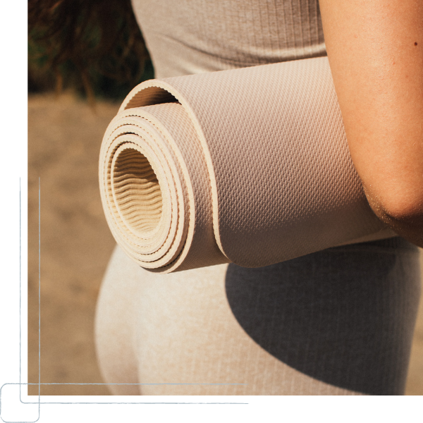 woman holding a beige yoga mat woman holding a beige yoga mat