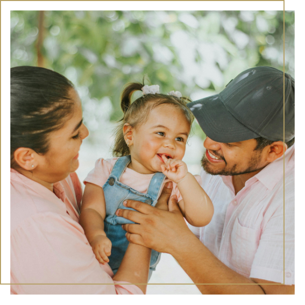 Una madre y un padre hispanos sonríen con ternura a su pequeña hija en los Estados Unidos.