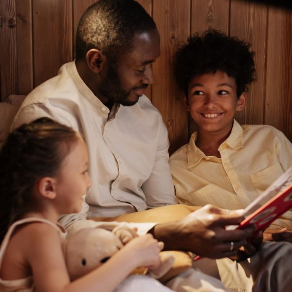 Parent reading book with kids