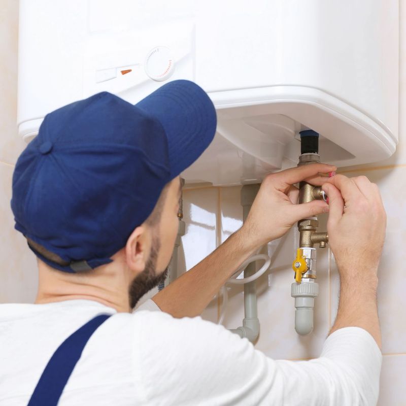 man installing tankless water heater