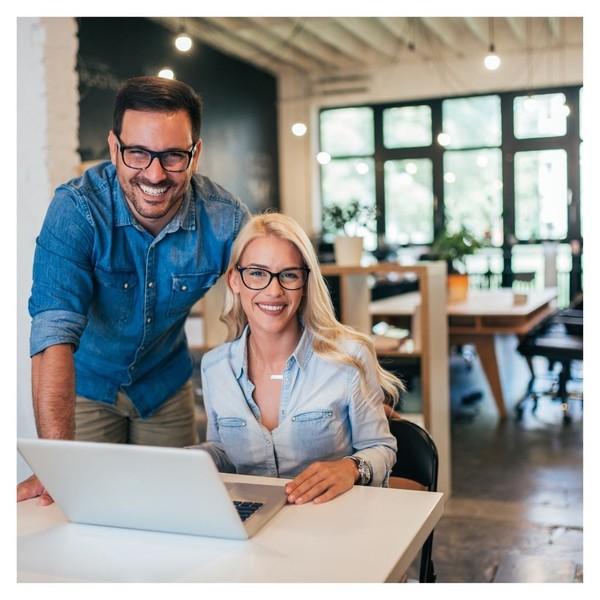 two business owners in shop looking at laptop