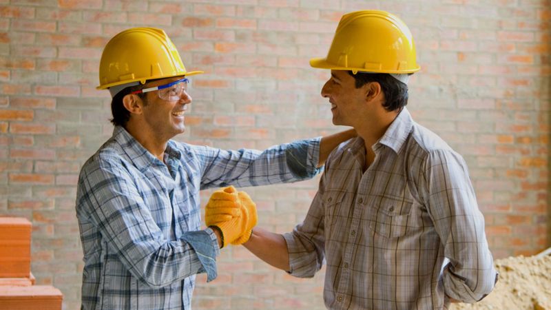 construction contractor shaking hands with client