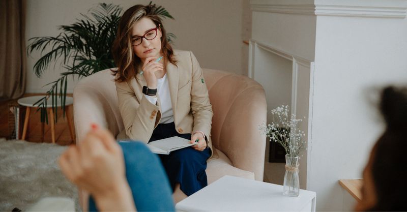 Woman listening thoughtfully with notebook in hand