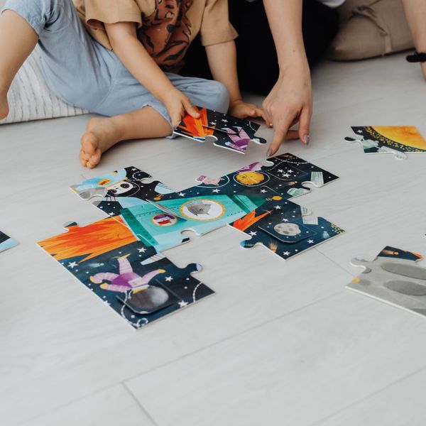 Parent and child putting together a puzzle. Parent and child putting together a puzzle.