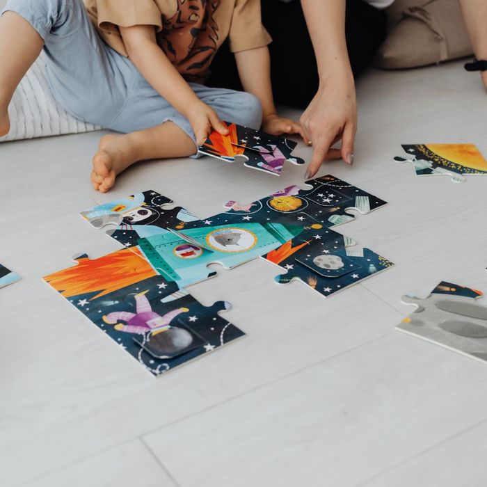 Parent and child putting together a puzzle.