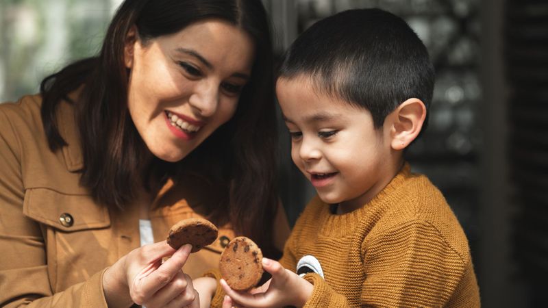 mother and son holding chocolate chip cookies