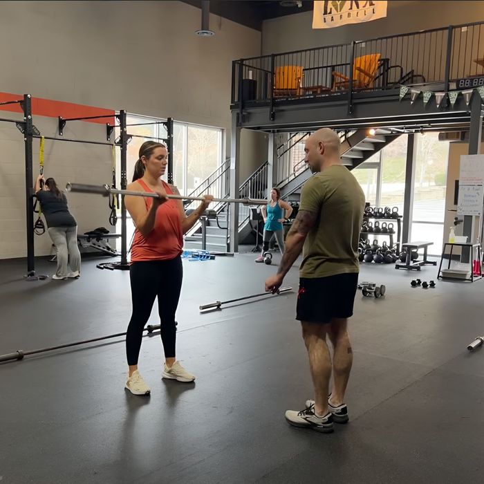 personal trainer assisting client