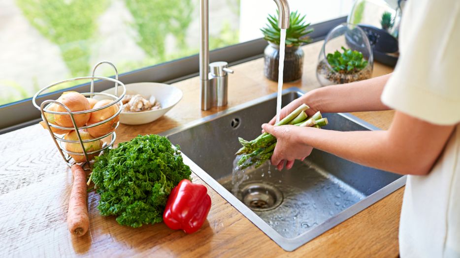 Woman washing fresh vegetables