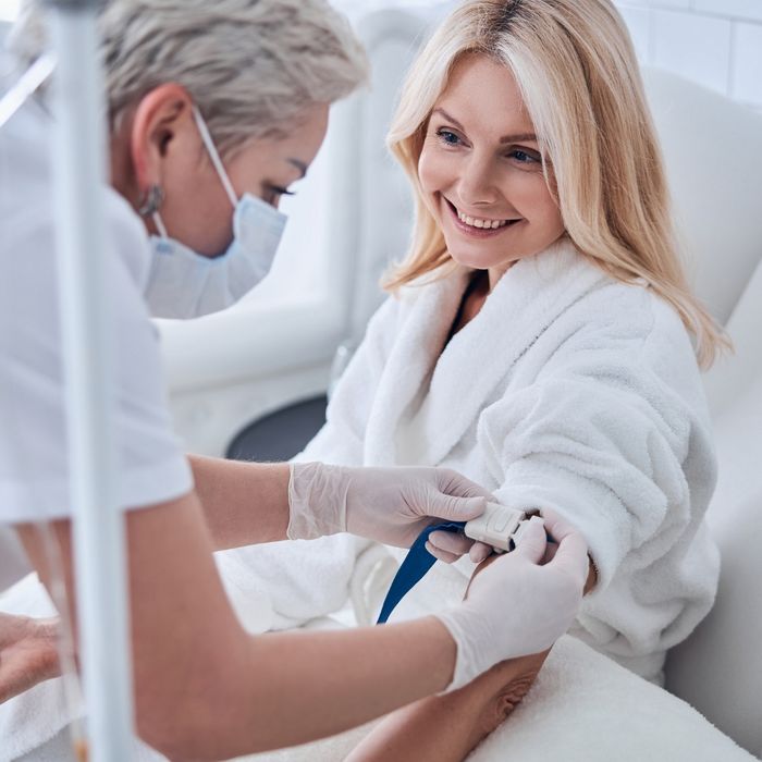 Woman smiling while getting IV hydration therapy