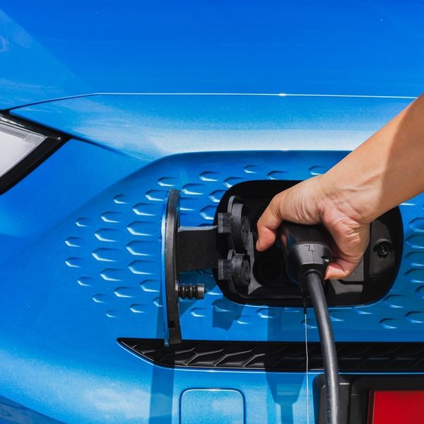 blue electric car with charger attached blue electric car with charger attached