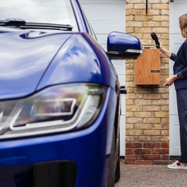 woman plugging in electric car woman plugging in electric car