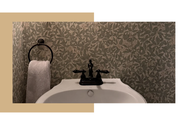 Green wallpaper behind a bathroom sink