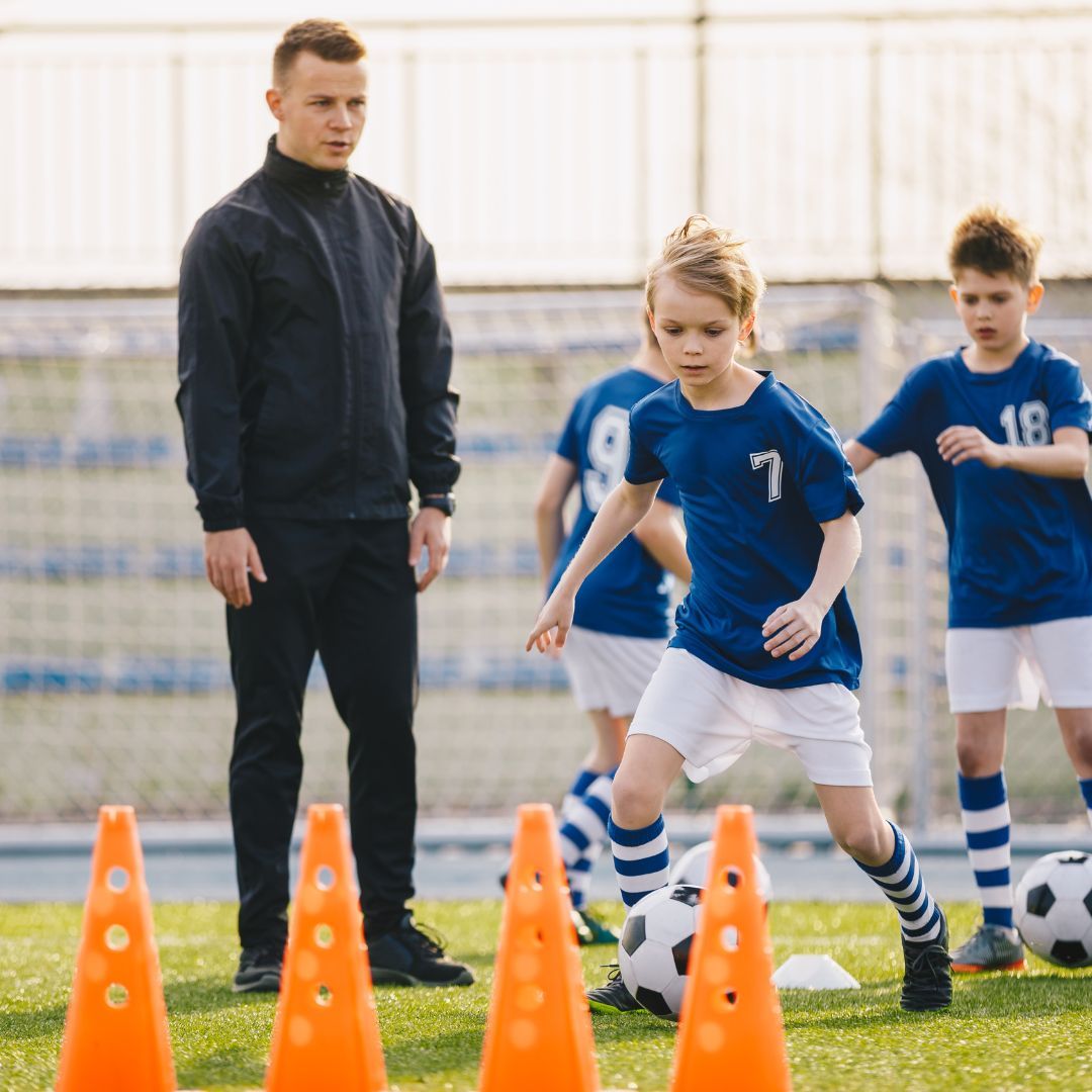 A youth soccer coach doing drills with team
