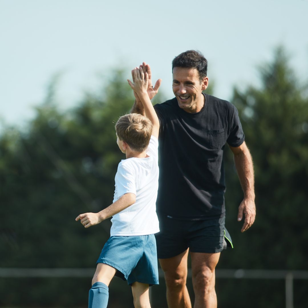 A youth soccer coaching giving a teammate a high-five