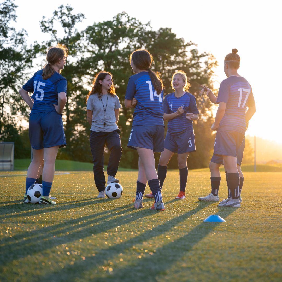 A youth soccer coach talking with teammates