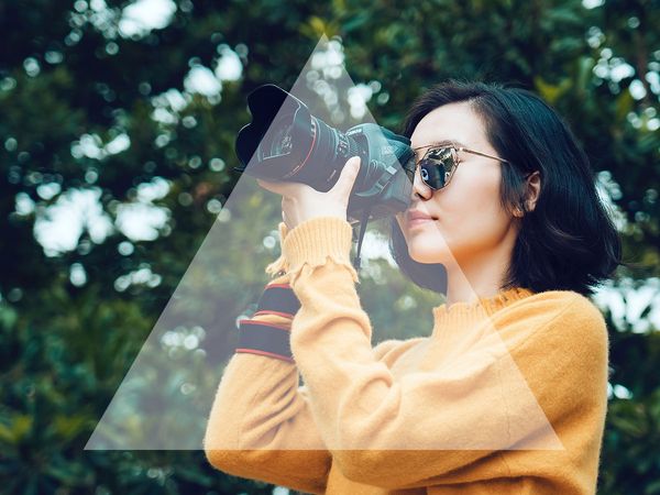 Image of a woman taking a picture with a triangle