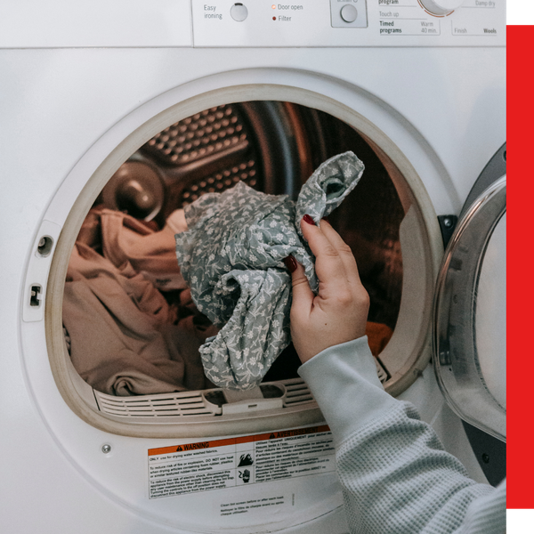 woman putting clothes in washer woman putting clothes in washer