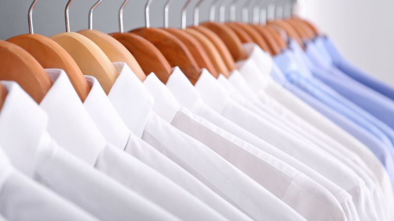 dress shirts hanging on a rack after dry cleaning