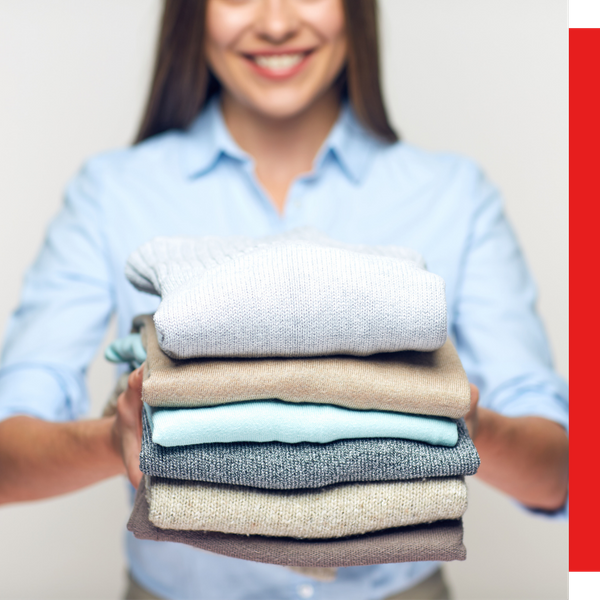 woman holding out folded clothes