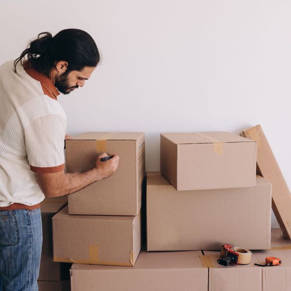 man labeling moving boxes