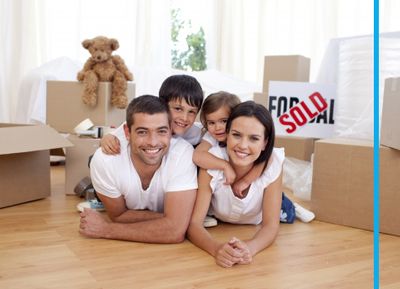 Family smiling on the floor with their moving boxes