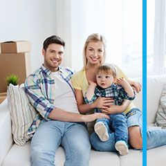 Family sitting on a couch surrounded by moving boxes