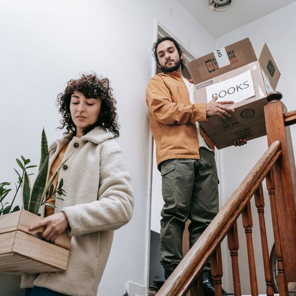 couple carrying boxes down stairs