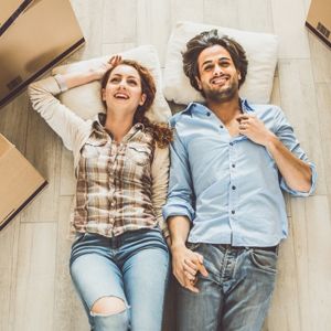 couple Laying on the floor surrounded by moving boxes