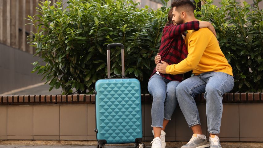 Two people hugging on a bench before a move