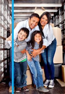 Family smiling in the back of their moving truck