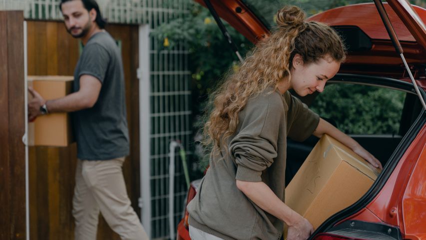 Man and woman moving boxes out of a truck