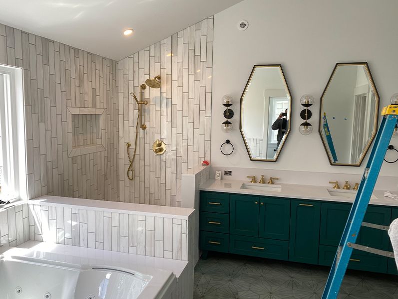 a remodeled bathroom with gray and white tile and a green vanity